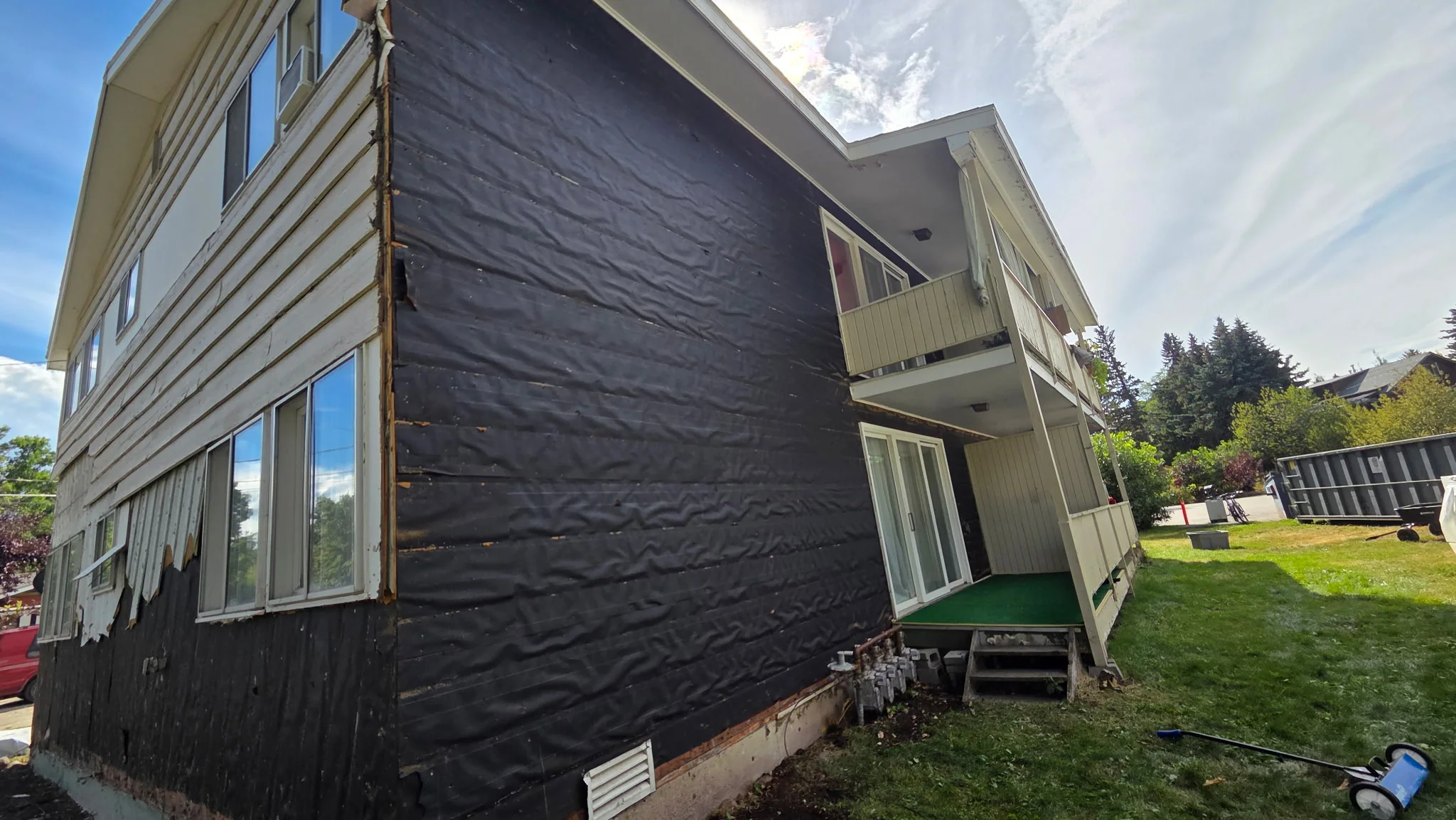 Siding stripped to sheathing on house exterior